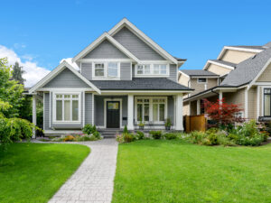 Two-story suburban home with gray siding and white trim. Navy blue front door